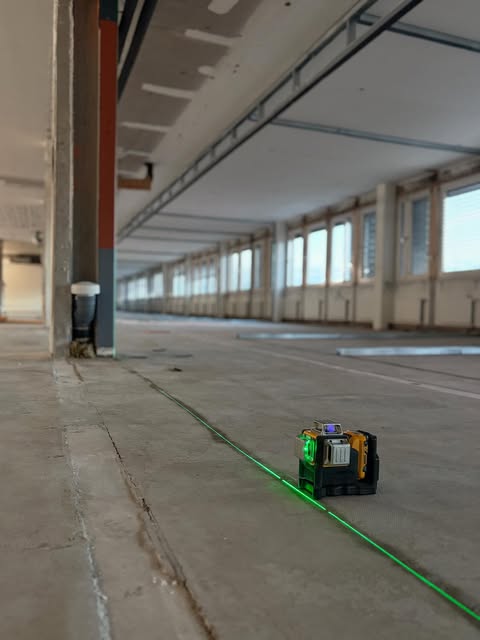 Stort tomt butiksplan med betonggolv och laserinmätning på golvet